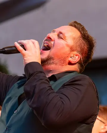 Alexander Lühr singt mit erhobenem Kopf ins Mikrofon.