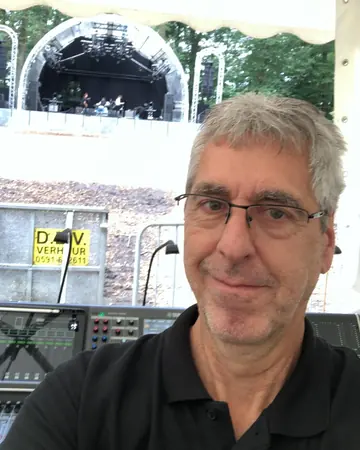 Andreas Hildebrand lächelt vor einer Freilichtbühne.