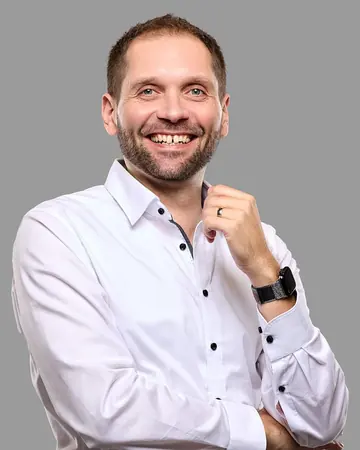 Claudio Becker-Foss lacht im weißen Hemd.