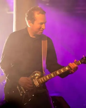 Daniel Boldt spielt E-Gitarre im violetten Bühnenlicht.