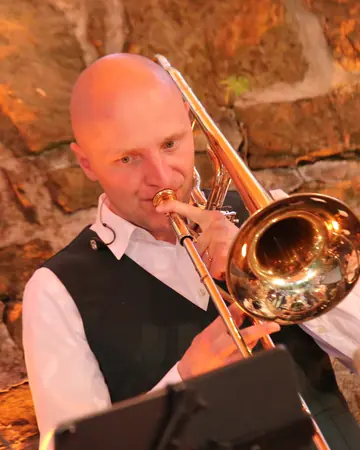 Jan Sören Damköhler spielt Posaune vor der Felswand.