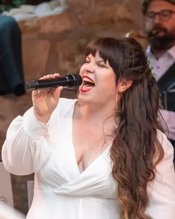 Jana Meyerdierks singt im weißen Kleid mit voller Stimme.