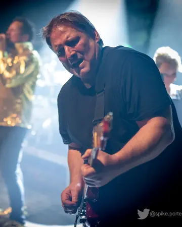 Lutz Feuerhahn spielt Gitarre im Gegenlicht.
