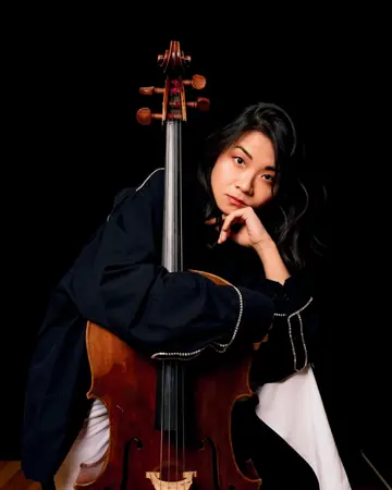 Sung-Yueh Chou sitzt mit ihrem Cello vor schwarzem Hintergrund