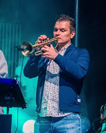Philipp Broscheid spielt Trompete im grünen Licht.